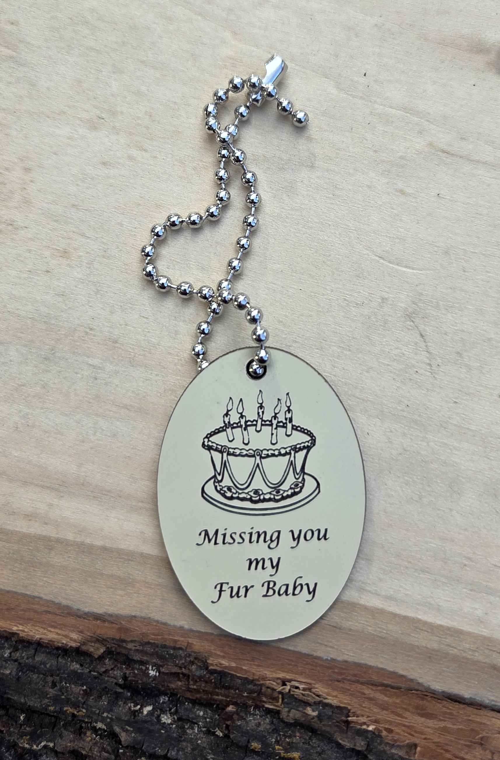 EC Angle Charm image of a Birthday Cake on ivory finish and silver chain.  Custom engraving and hand made for  family.