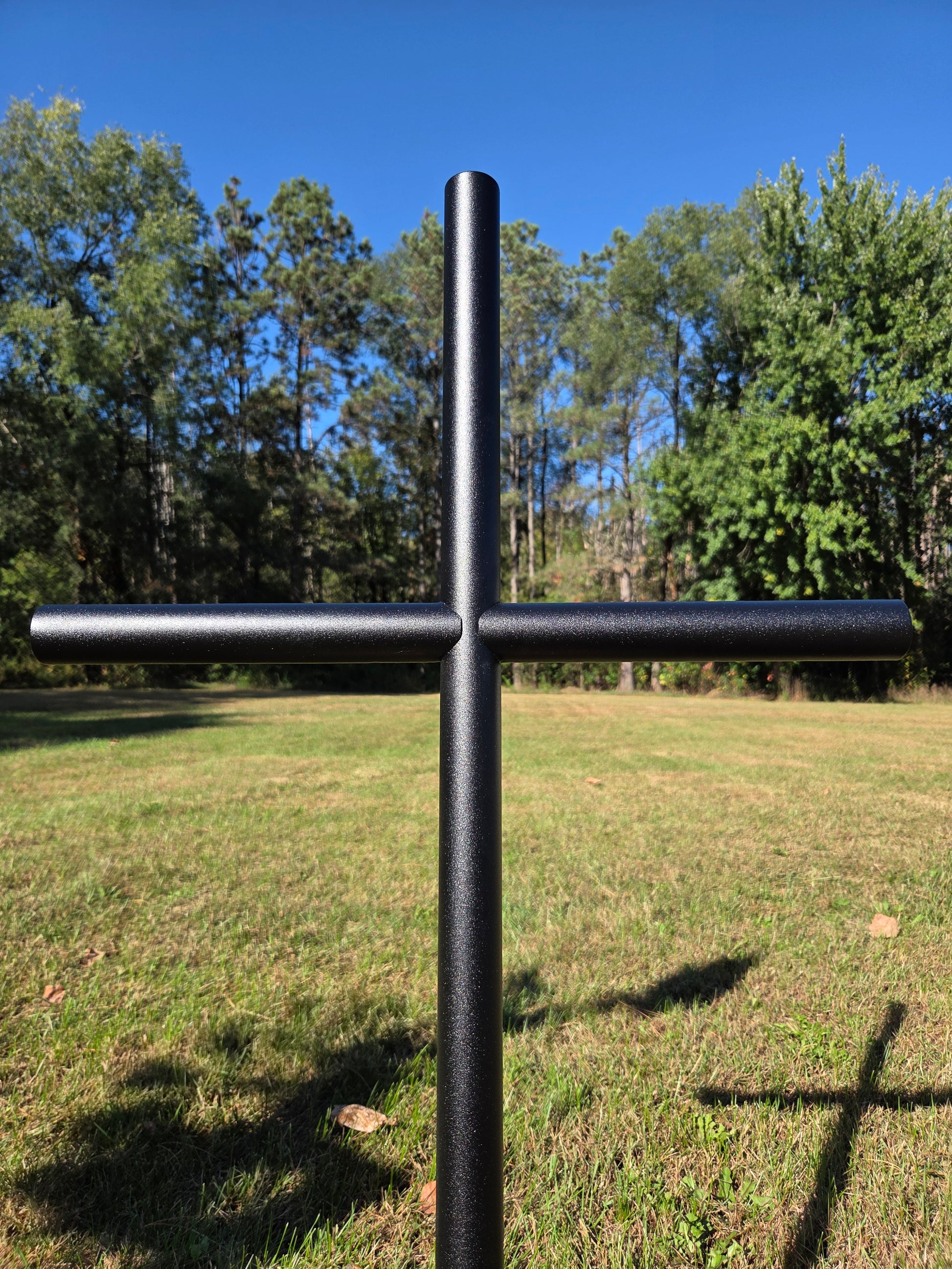 Black Ebony EC memorial cross shown in a close view to display this textured classic finish, as the sunlight dances and honors their memory. 