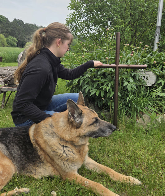 Memorial Everlasting Cross shown in large size 21 inch wide by 41 inch tall, Copper Vein finish, young girl grieving from the lost a fur baby.  Remembering him with her dog. 