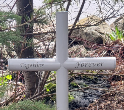 Lake side memorial is shown in small size Everlasting Cross 13 inches wide by 32 inches tall, with White Stainless steel end caps.  Uniquely engraved Together Forever resting in its forever placement.  